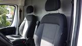 Two black fabric front seats of a 2017 RAM Promaster with headrests and seatbelts visible