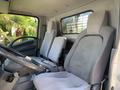 Interior of a 2015 Isuzu NPR showing two gray upholstered seats and a steering wheel visible in the foreground