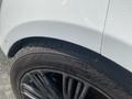 A close-up view of a white 2020 Land Rover Range Rover Sport showing its wheel and tire with water droplets visible on the surface