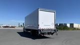 A 2019 International 4300 box truck with a white exterior parked on a paved area, featuring a large cargo space and a visible rear bumper with lights