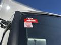 A close-up of a 2020 Hino 195 truck's windshield displaying a red certificate of approval sticker with months listed from January to April