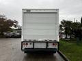 A white 2012 Mitsubishi Fuso FE truck viewed from the rear featuring a plain back door and visible tail lights