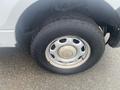 A close-up of a tire on a 2013 Ford F-150 showing a silver wheel with five holes and a worn tread pattern