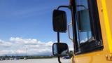 A yellow 2014 International 3000 school bus with a side mirror visible from the driver's perspective