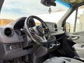 Interior view of a 2019 Mercedes-Benz Sprinter showing the steering wheel dashboard and console with various controls and cup holders