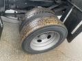 A close-up of a dirty double rear tire from a 2021 Ford F-550 showcasing the tread pattern and wheel rim