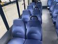 Interior seating of a 2018 Chevrolet Express with blue molded seats and black armrests arranged in rows