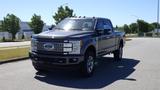 A 2017 Ford F-350 Super Duty in a dark color with chrome accents and a prominent grille parked on a street