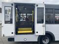 A 2018 Chevrolet Express bus with open rear doors and a yellow wheelchair ramp extended outside