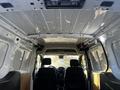 Interior view of a 2022 Ford Transit Connect showcasing the overhead ceiling with a metal structure and two front seats visible