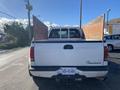 A white 2000 Ford F-350 SD viewed from the rear with a visible bed and tailgate featuring the International logo on the left side