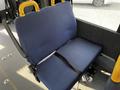 A blue upholstered bench seat in a vehicle with a seatbelt and yellow armrests