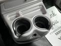 A close-up of a beige cup holder with two circular openings designed for beverages in a 2014 Kenworth T370