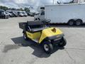 A yellow 1999 Ez-go Industrial utility vehicle with a black seat and a small rear cargo bed