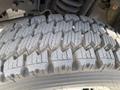 Close-up of a tire tread from a 2010 Ford F-550 showing deep grooves and patterns designed for traction on various surfaces
