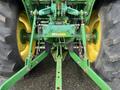 A 2003 John Deere 790 tractor featuring large rear tires and a green hitch assembly with various attachments and controls for agricultural use