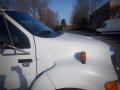 A white 2007 Ford F-650 truck with a distinctive angular front and an amber side marker light