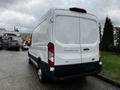 A white 2021 Ford Transit van with a high roof and rear doors partially open