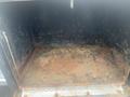 An empty and rusty cargo bed of a 2015 Chevrolet Silverado 3500HD showing dirt and debris