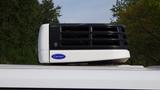 A rooftop air conditioning unit labeled Carrier mounted on a 2017 RAM Promaster van