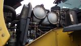 Close-up of the engine compartment of a 2019 Caterpillar 972M XE featuring large silver exhaust components and various mechanical parts