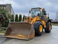 A yellow Hyundai wheel loader with a large bucket in the front and heavy-duty tires