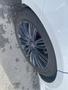 Close-up of a black alloy wheel on a white 2020 Land Rover Range Rover Sport showing intricate spoke design and a sporty tire