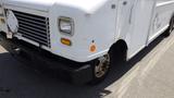 White 2011 Ford Econoline with a flat front and large grille featuring round headlights and an orange turn signal