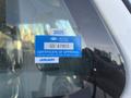 A blue certificate of approval sticker on a vehicle window displaying text about the approval number and expiration dates