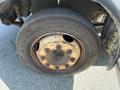 Close-up of the wheel of a 2010 Freightliner MT45 garbage truck showing a rusty rim and an old tire with visible wear and tear