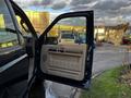 A blue 2008 Ford F-250 SD with its driver's side door open revealing a beige interior and dashboard