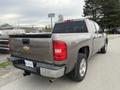 2013 Chevrolet Silverado Hybrid with a gray exterior parked on a gravel surface showing its rear and driver's side view