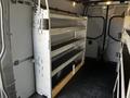 A 2021 Mercedes-Benz Sprinter van interior featuring metal shelves affixed to the side, designed for storage and organization of tools or equipment