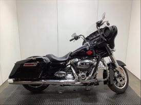 A 2022 Harley-Davidson FLHT motorcycle in black with chrome accents featuring a large windshield and comfortable seat