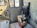 Interior of a 2010 Freightliner MT45 Garbage Truck featuring a driver's seat and a cardboard box containing various items