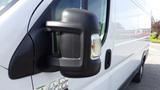 Close-up of the side mirror on a 2017 RAM Promaster van featuring a black casing and integrated turn signal light