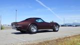 A 1971 Chevrolet Corvette Stingray in a deep brown color with a sleek design and chrome wheels parked on a paved surface