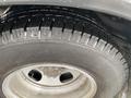 A close-up view of a tire on a 2017 Chevrolet Express showing its tread pattern and alloy wheel underneath