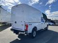A white 2019 Ford F-350 SD with a high cargo cap on the truck bed and 4x4 detailing