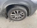 A close-up of a silver alloy wheel from a 2021 Lexus NX 300 with a tire showing signs of wear and dirt