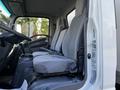 A 2020 Isuzu NPR with gray upholstered seats and a simple interior design featuring a steering wheel and gear shift