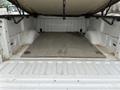 An empty truck bed of a 2010 Ford F-150 with a flat wooden floor and raised sides