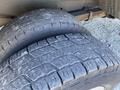 Close-up view of two heavily worn tires on a 2008 Ford Econoline displaying deep tread patterns and visible signs of wear and tear on the rubber surface