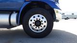 Close-up of a wheel and tire from a 2012 International DuraStar 4300 featuring a shiny silver rim and a large black tire marked with the Goodyear brand