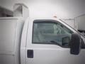 A white 2008 Ford F-550 utility truck with a flatbed and a storage compartment attached on the rear