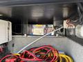 Inside the storage compartment of a 2008 Newmar Canyon Star 36 Foot Class A Motorhome with visible cables and tools including power cords and battery wires