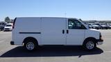 A 2012 GMC Savana cargo van in white with a simple design and chrome wheels viewed from the side