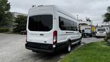 A white 2017 Ford Transit van parked with tinted windows and a high roof showcasing a spacious rear design