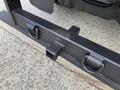 Close-up of a sturdy black bumper on a 2012 Ford F-550 featuring two towing hooks and a receiver hitch attachment point