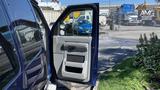 2013 Ford Econoline van with the driver's side door open showcasing the interior design and controls